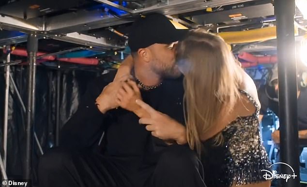 Taylor Swift and Travis Kelce share a kiss beneath the stage in the docuseries trailer.