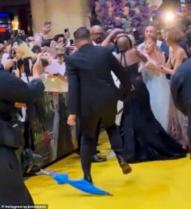 Cynthia Erivo steps between Ariana Grande and a rushing man at the Wicked: For Good Singapore premiere.