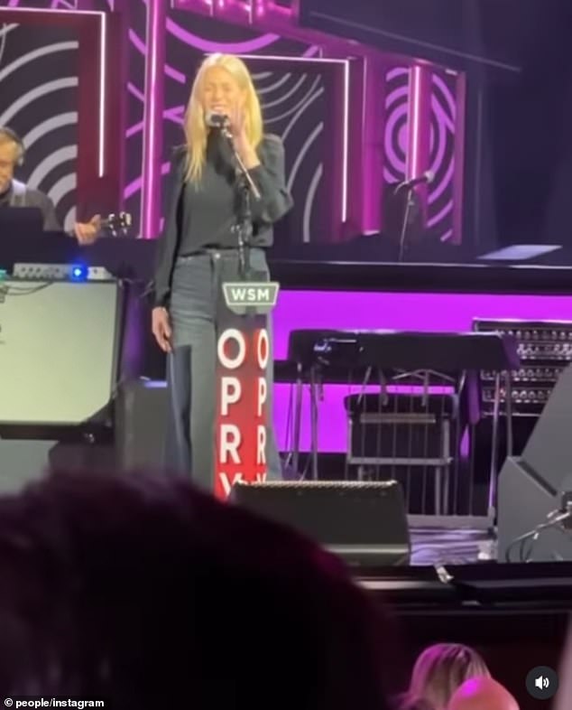Gwyneth Paltrow sings onstage with Holly Williams at the Grand Ole Opry during the venue's 100th anniversary celebration.