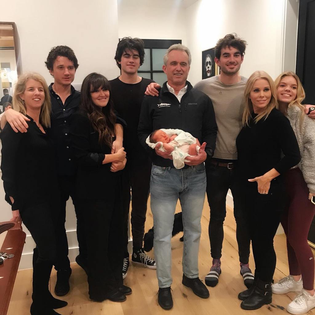 Robert F. Kennedy Jr. holding a newborn, surrounded by his children, with Cheryl Hines.