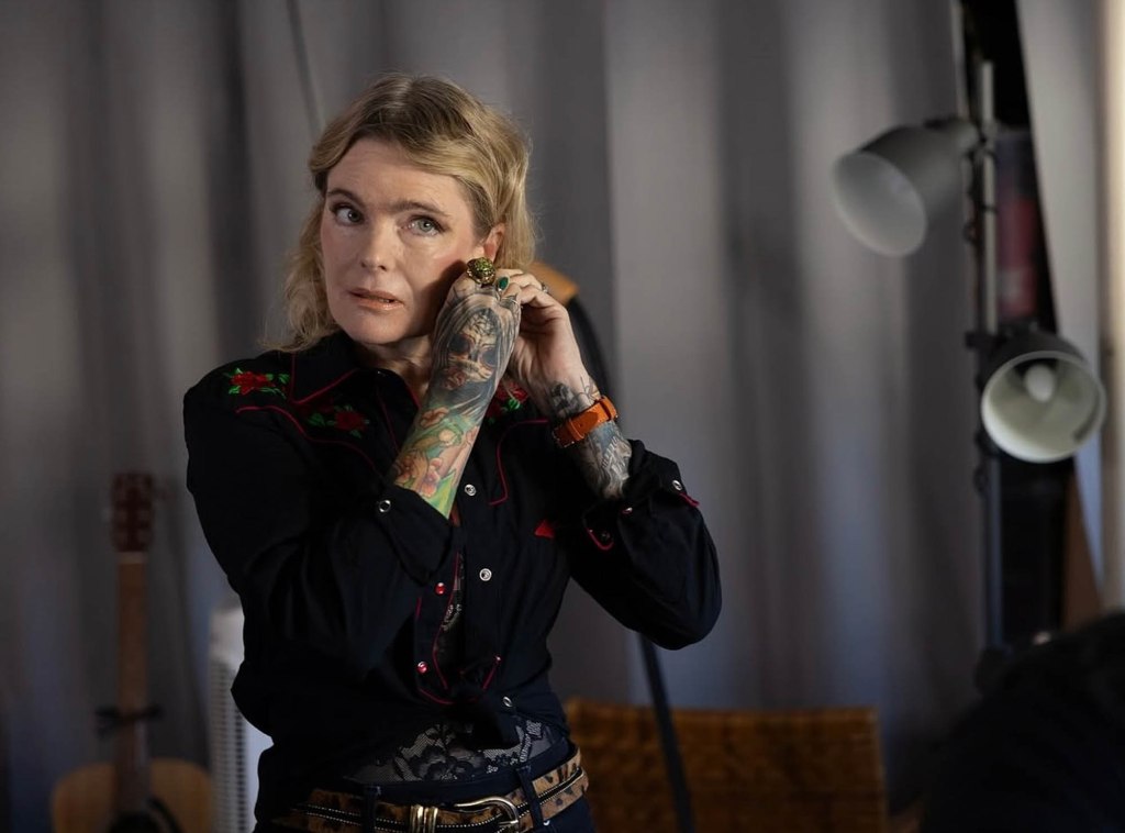 Erika Eleniak shows off sleeves of tattoos in a black embroidered jacket while celebrating wrap on Alchemy in Venice.