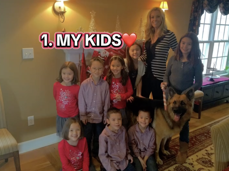 Kate Gosselin with her eight children and a dog in a living room decorated for Christmas.