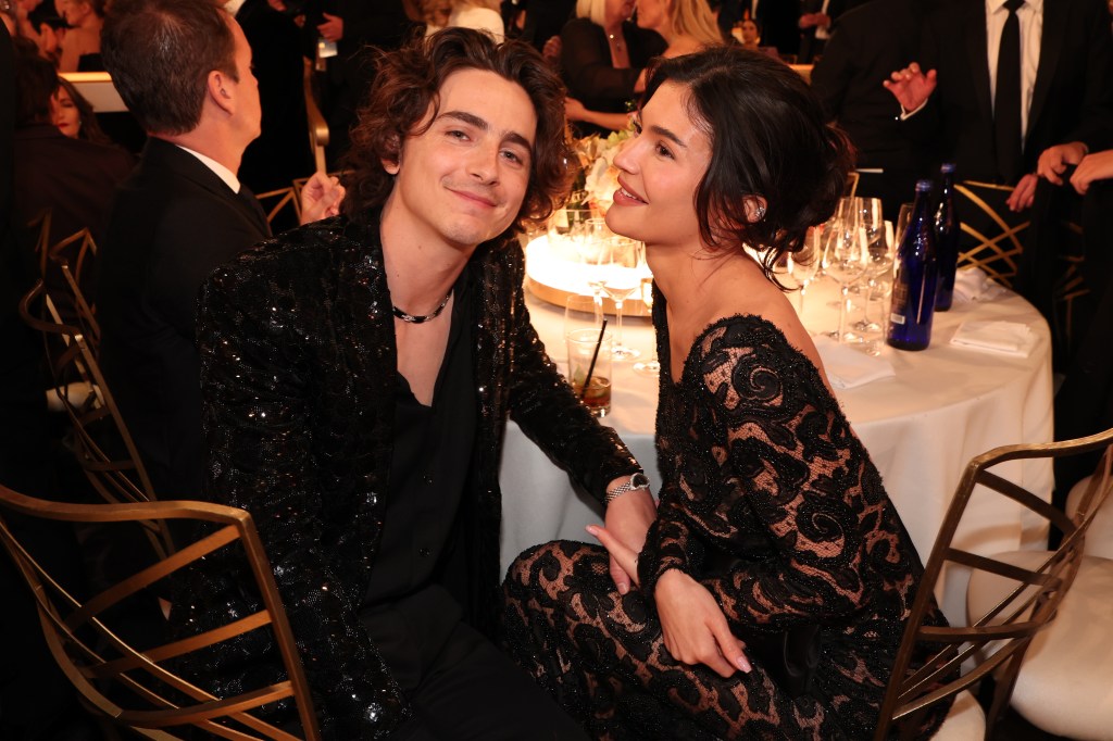 Timothee Chalamet and Kylie Jenner seated at a table at the Golden Globes Awards.