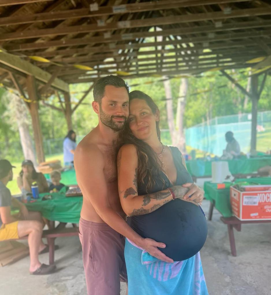 Penn Badgley embraces his pregnant wife, Domino Kirke.
