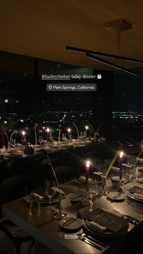 A table setting with a menu for a "rhode" event, a name card for "Amber", and a small yellow block with the word "rhode" on it.