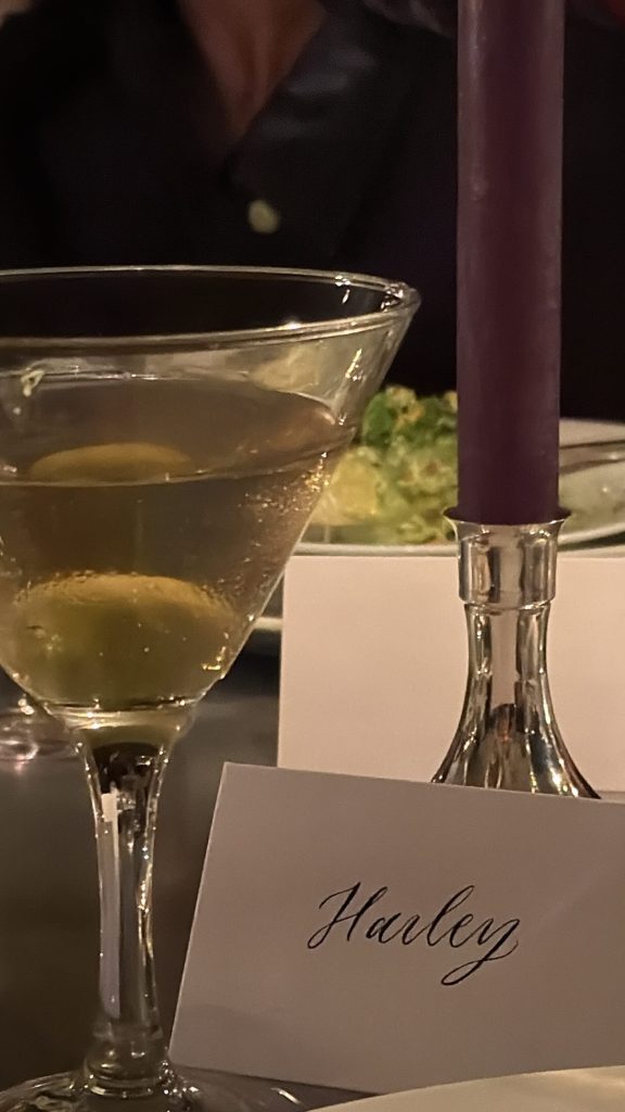 A martini glass with olives and a place card that reads "Hailey".