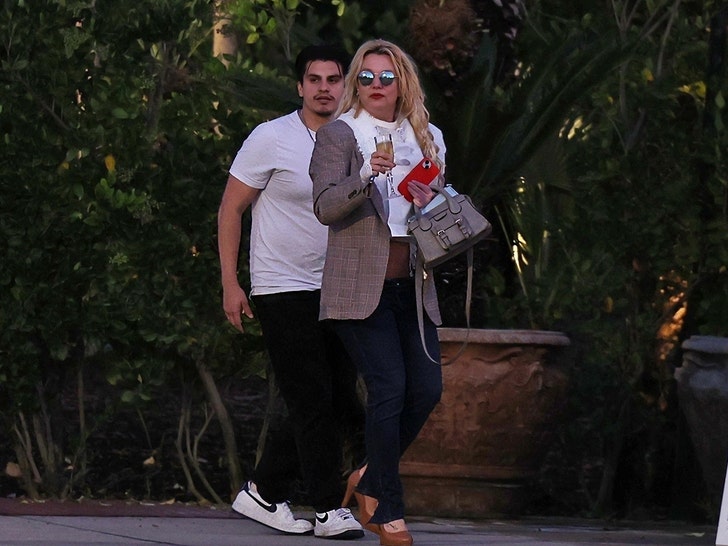 Britney Spears leaving The Westlake Village Inn in a sharp blazer and sunglasses, carrying a designer handbag and holding a glass of sparkling wine.