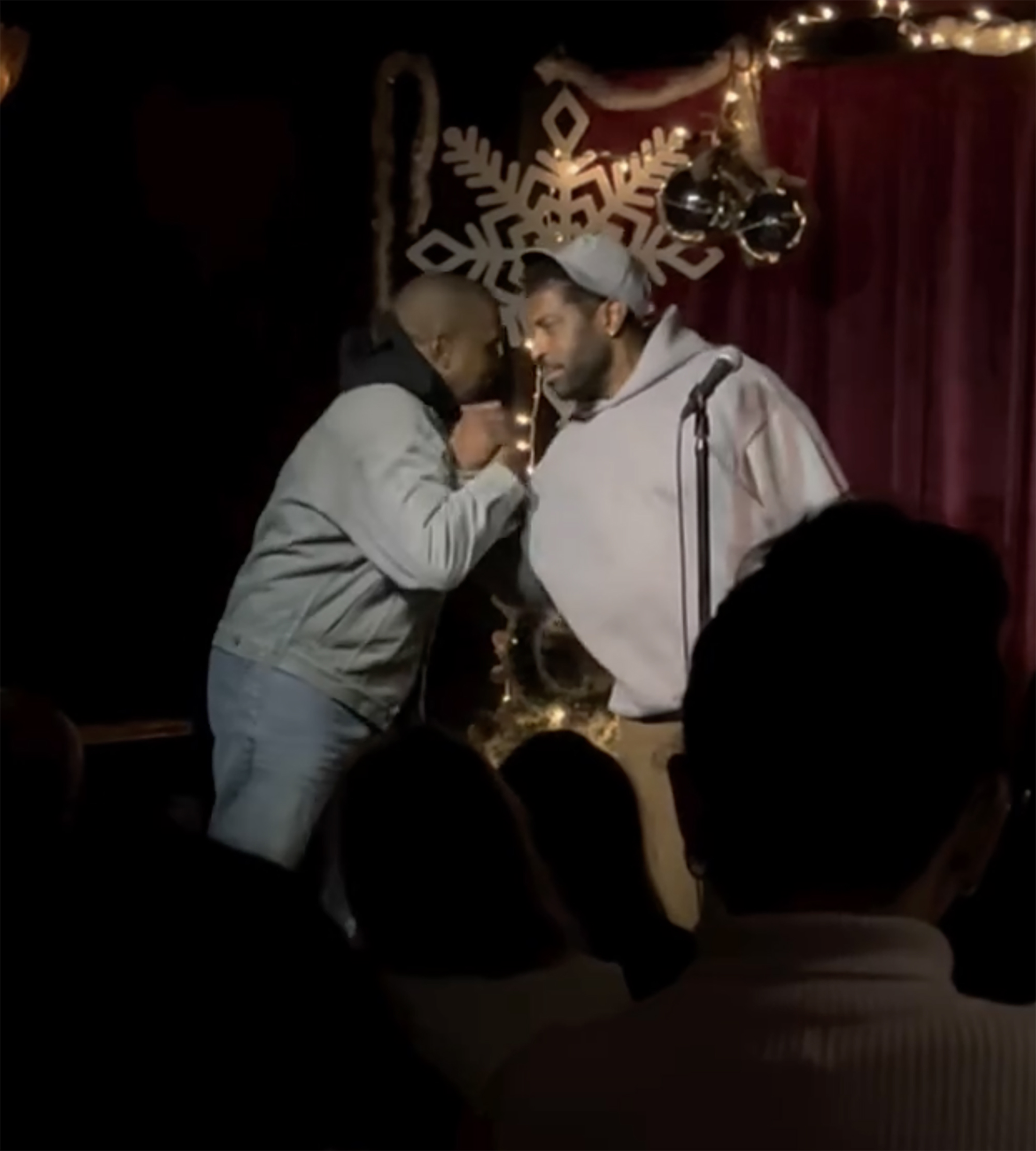 Kanye West and Deon Cole face each other onstage.