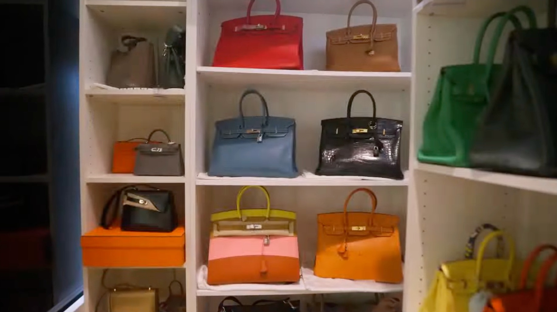 Shelves displaying rare Birkins, including the yellow-pink-orange Sunrise Rainbow Limited Edition.