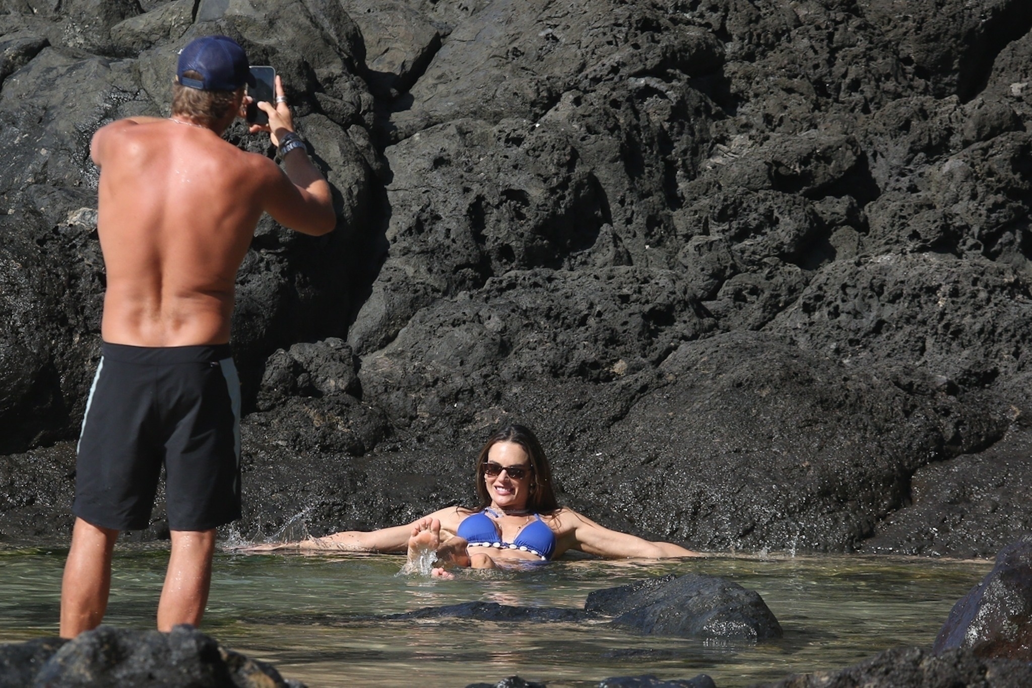 Buck Palmer takes a photo of Alessandra Ambrosio in a shell-studded blue bikini at Boda Beach in Pernambuco, Brazil.