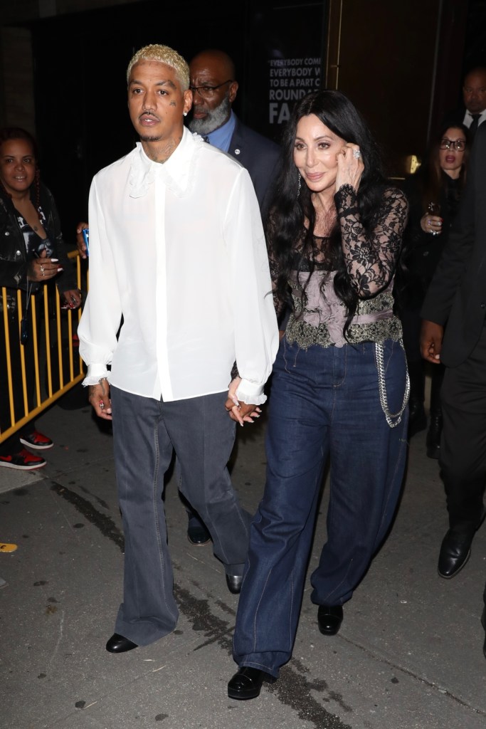 Cher and AE holding hands and smiling at a Valentino Beauty event. (ALEXJR / BACKGRID)