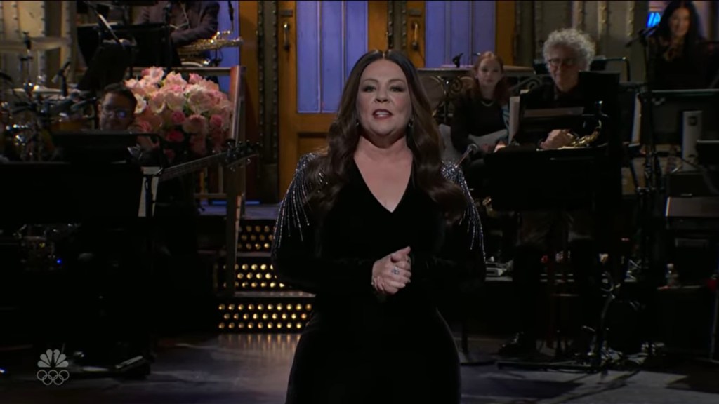 Melissa McCarthy delivers her monologue in a black velvet jumpsuit during her SNL hosting return.