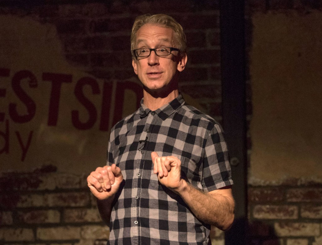 Andy Dick performing on stage at a comedy show.