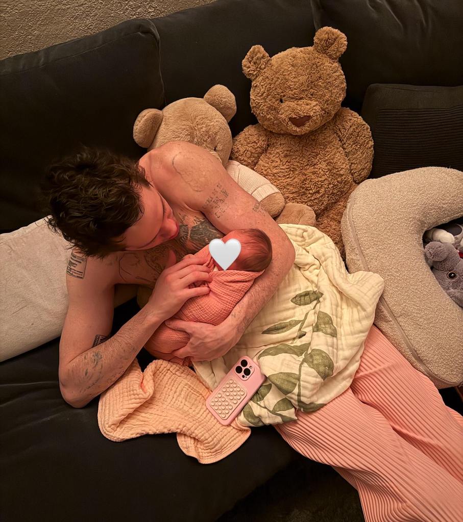 Pete Davidson sits shirtless on a couch, holding his newborn daughter, Scottie, against his chest during skin-to-skin bonding.