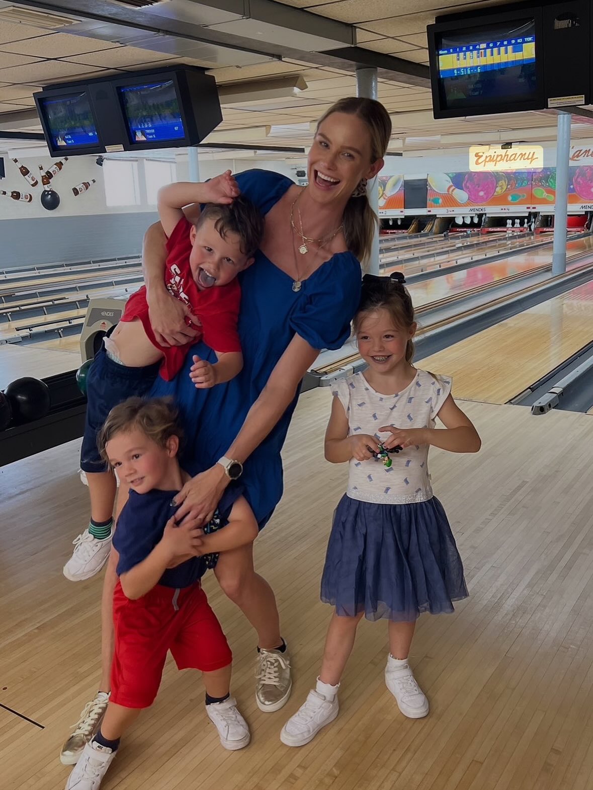 Meghan King with her three children at a bowling alley.