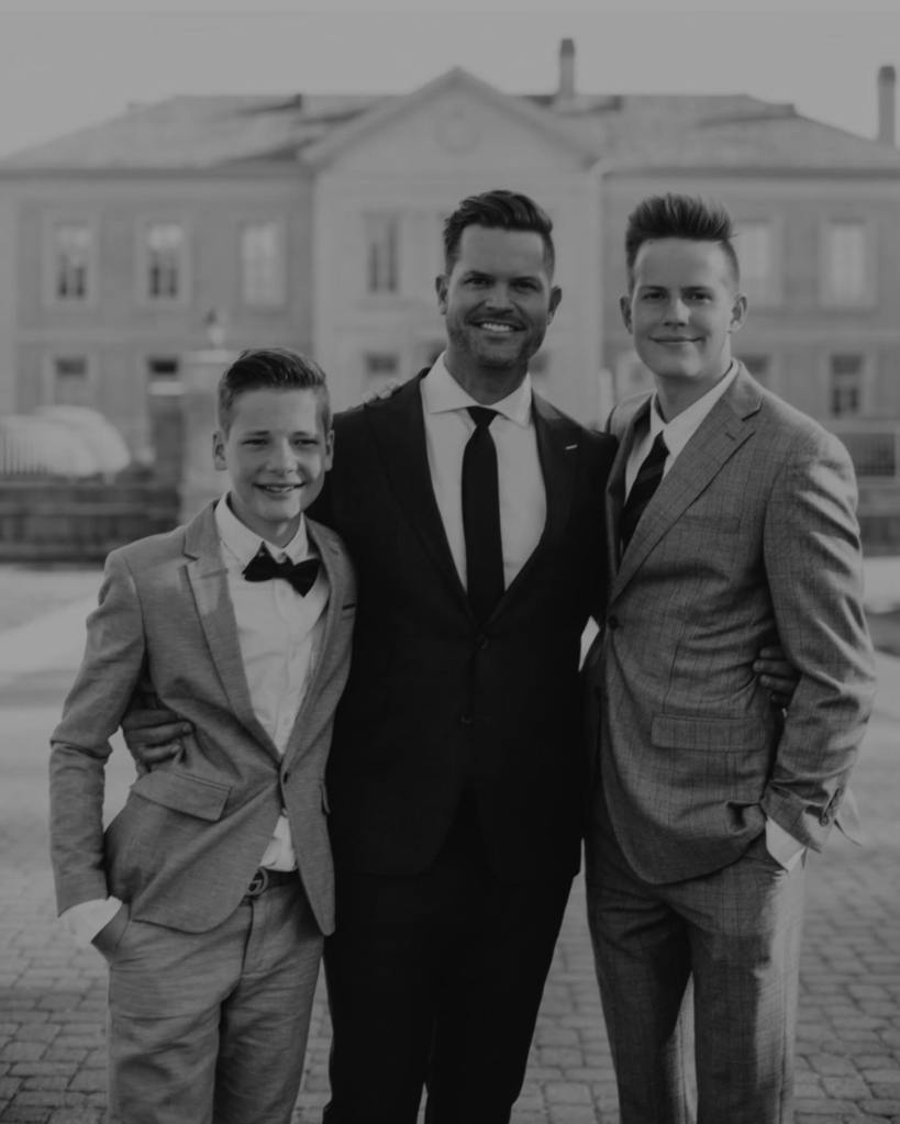 Bret Engemann with his two sons, dressed in suits.