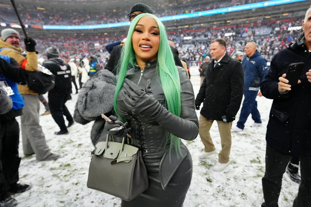 Cardi B shows off her custom all-leather Jagne game-day outfit on the snowy field.