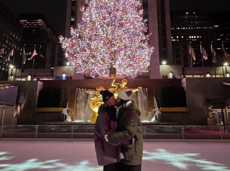 Keanu Reeves and Alexandra Grant kissing on an ice rink in front of the Rockefeller Center Christmas tree.
