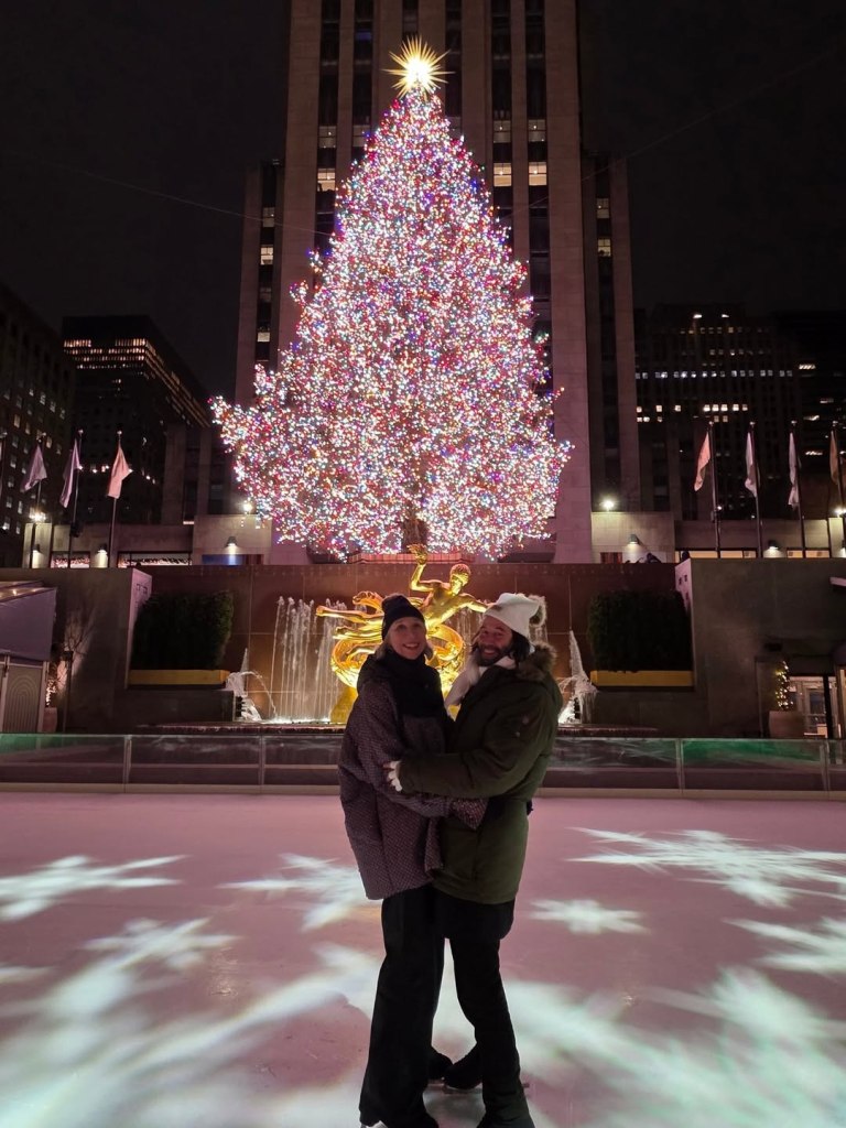 Keanu Reeves and Alexandra Grant ice skating in front of the Rockefeller Center Christmas tree.