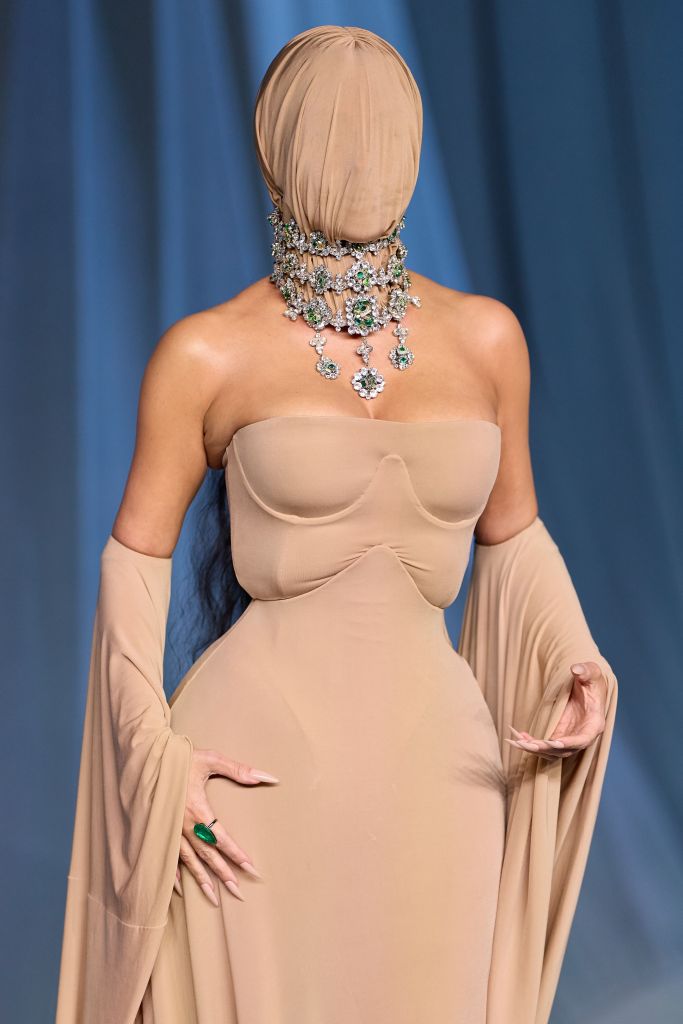 Kim Kardashian in the beige hooded Margiela gown with a statement necklace at the Academy Museum Gala.
