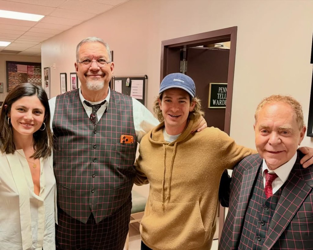 Andrew Garfield with blond hair poses backstage with Penn Jillette, Teller, and Monica Barbaro at the Rio in Las Vegas.