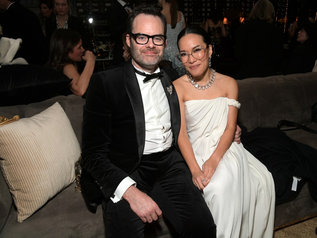 Bill Hader and Ali Wong seated together on a couch at a Golden Globes after-party.