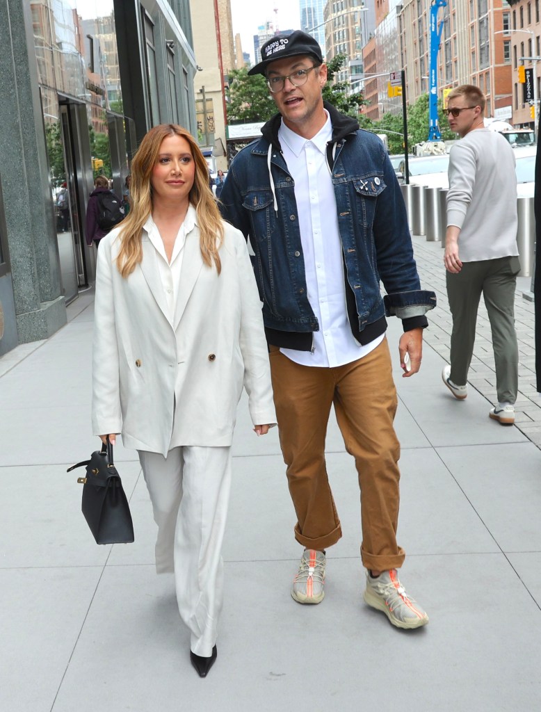 Ashley Tisdale and Christopher French walking side-by-side on a city street.