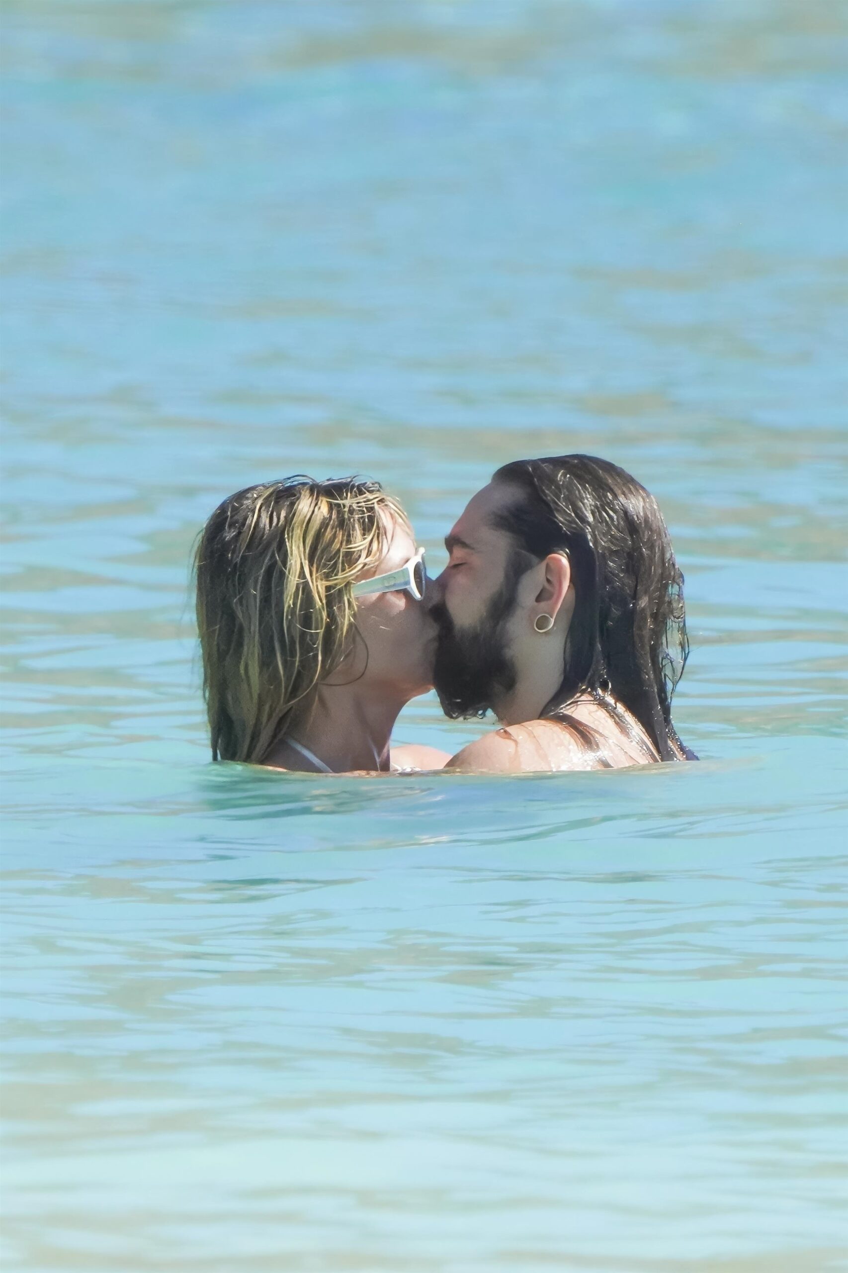 Heidi Klum and Tom Kaulitz kiss in clear ocean water at St. Barts.