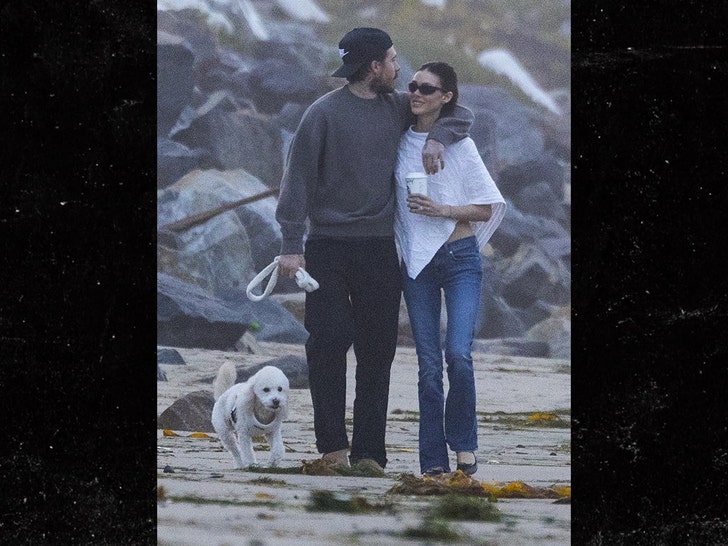 Brooklyn Beckham and Nicola Peltz hold hands during a calm stroll along the Malibu shoreline.
